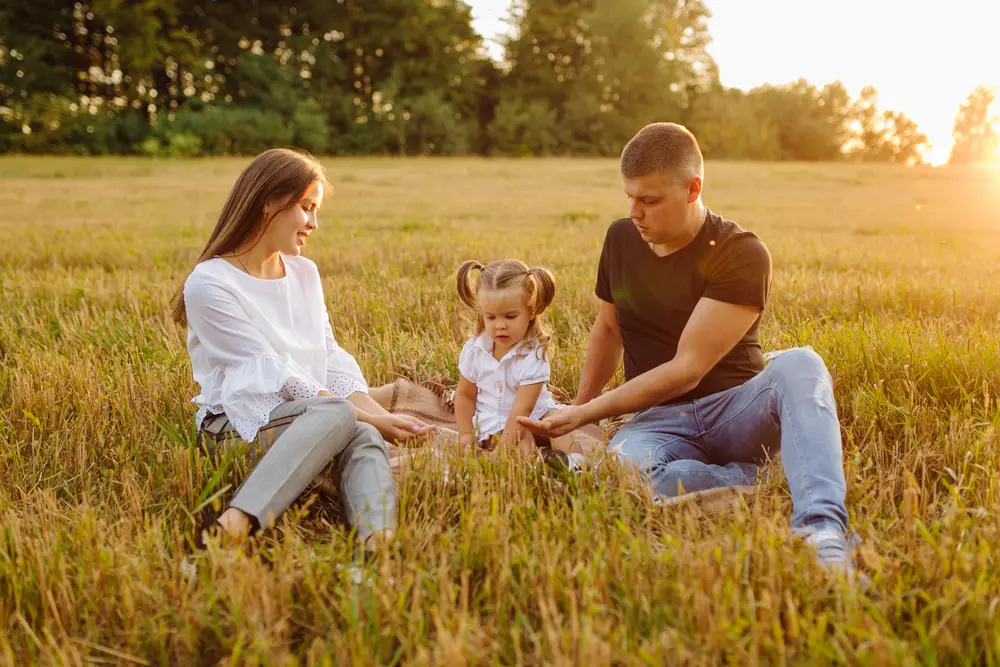 Family relaxing in a sunset field in Waller County, Texas